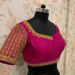 A closer look at a bridal blouse designed for wedding festivities. The sleeve is fully covered in a dense, repeating pattern of gold zardosi embroidery for a rich, textured look.