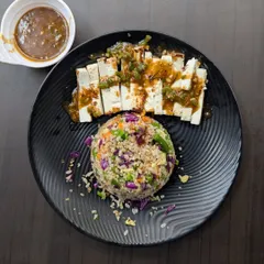 For a satisfying plant-based option, I offer this dish of sliced tofu served with a colorful mound of vegetable-infused rice. It's a great way to meet your protein needs without meat.