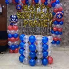 For a young superhero fan, I designed this Captain America themed birthday decoration. The setup features a balloon arch in the hero's signature red, white, and blue colors, star-shaped foil balloons, and a Captain America figure on a balloon pillar.