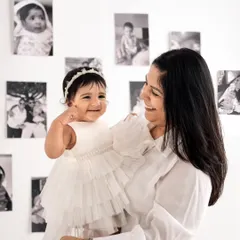 A beautiful mother and daughter portrait, with generations of family photos creating a meaningful background.