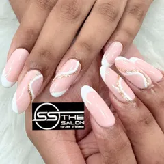 This elegant design combines a classic French tip with a modern artistic flair. A delicate swirl of gold glitter flows across a soft pink base, creating a sophisticated and eye-catching look on temporary nail extensions.