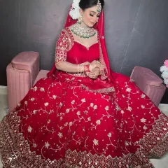 A closer look at the detailing on the red velvet lehenga, showing the sweetheart neckline and the intricate work on the blouse.