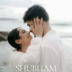 An intimate close-up on the beach, her hands framing his face. A simple, raw, and powerful portrait of affection.