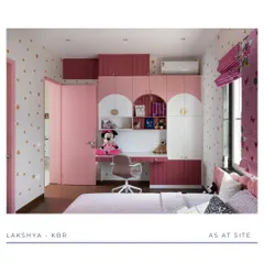 This view showcases the integrated study unit in a dreamy pink kid's room. The desk is built into the wardrobe, with open shelving for books and toys, creating a functional space for both play and learning. The heart-patterned wallpaper adds a whimsical touch.
