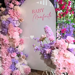 For a truly breathtaking baby shower, I can design a wall of flowers like this one. The vibrant pink and purple artificial flowers create a luxurious and memorable photo backdrop for your special day.