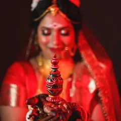 The beauty of tradition is in the details. This portrait of a beautiful Bengali bride focuses on the 'sindoor daan' ritual, using rich red lighting to highlight the significance and emotion of the moment.