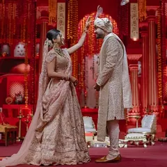 A beautiful ritual during the 'Lal Bagh' ceremony. Our design ensures that even in a grand setting, the focus remains on the couple and the sacred traditions they are observing.
