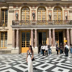 Exploring the magnificent Palace of Versailles. I chose a long, white slip dress with black lace details, creating a romantic and elegant silhouette that felt right at home in such a historic and opulent setting. The bow in my hair adds a soft, feminine touch.
