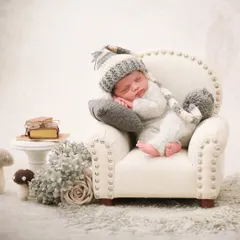This little one is styled as a sleepy gnome, dozing in a miniature armchair with tiny books and mushrooms to complete the whimsical scene.