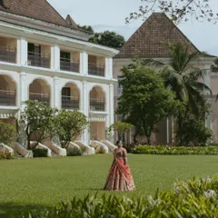 A bridal portrait set against the lush lawns and Portuguese-style architecture of a luxury resort in Goa, perfectly capturing the destination wedding vibe.