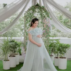 A beautiful solo shot celebrating motherhood. The gown's front slit is visible here, a feature designed to gracefully showcase the baby bump during a maternity session.
