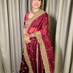 Beauty in red for the mother of the bride. She looks absolutely radiant and happy in a classic red and gold outfit, with makeup that is both elegant and age-appropriate.