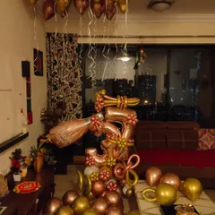 Here is a complete living room setup for a 3rd anniversary. The decor is centered around a custom balloon sculpture and includes helium balloons on the ceiling to fill the room and create a party atmosphere.