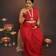 Holding a diya, the lamp of life, this portrait is rich with symbolism. The warm glow illuminates her face, creating a serene and deeply traditional maternity photo.