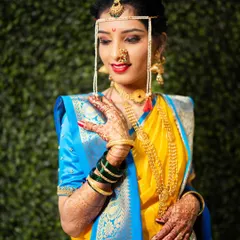 A classic bridal portrait showcasing the stunning details of Maharashtrian jewelry, from the nath to the intricate necklaces.
