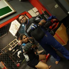 Me training with one of our dedicated female fighters inside the cage. We push every student to their limits, ensuring they are ready for any challenge.