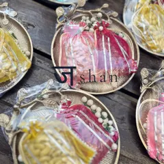 From my 'Jashn' collection, these festive favors feature utilitarian gold platters holding organza potlis filled with roasted nuts. They are a beautiful symphony of warmth and elegance, perfect for Diwali or wedding celebrations.