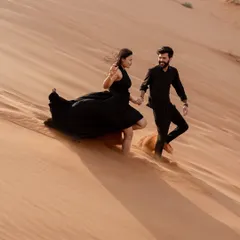 Capturing movement and joy as the couple runs down a sand dune. The flowing dress and the golden light create a beautiful, dynamic image full of life.