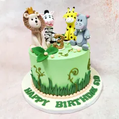 This vibrant green jungle cake is topped with a friendly crew of fondant animals: a crowned lion, a cheeky zebra, a smiling giraffe, and a happy hippo.