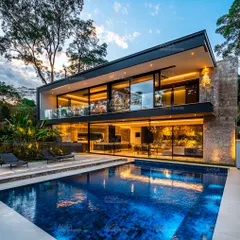 For this modern villa, I used floor-to-ceiling glass and a cantilevered upper level to create a home that feels open and connected to its beautiful surroundings. The design prioritizes natural light and offers stunning views from every room, with a sleek pool that completes the picture of modern luxury.