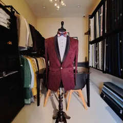 A custom maroon tuxedo with a subtle geometric pattern and a classic black shawl lapel. Displayed in my studio, this piece is ready for a festive occasion like a Christmas party or a wedding reception.