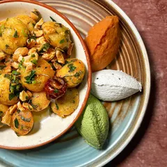 A closer look at the textures of our Gunpowder Idli. The vibrant colours of the chutneys contrast with the golden-brown idlis, promising a multi-layered taste experience.