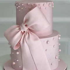 A gorgeous two-tiered pink cake featuring a large, dramatic bow. This design is perfect for a girly celebration and teaches skills in stacking and advanced fondant work.
