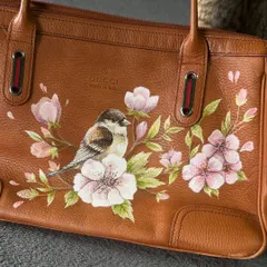 A close-up of the bird and blossoms. I use fine brushes and high-quality paints to achieve this level of realism on leather.