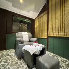 A quiet corner in our Guwahati center, featuring a comfortable pedicure chair set against natural textures like stone flooring and bamboo blinds to create a peaceful, earthy atmosphere.