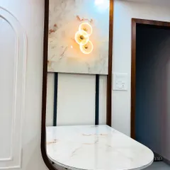 The finished folding table in its open position, featuring a beautiful marble-finish top. It is mounted within a decorative wooden frame that also houses an accent light.
