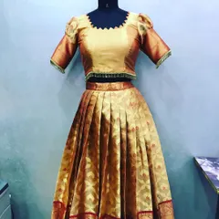 A complete lehenga set crafted from a golden pattu saree. The pleated skirt and custom-stitched blouse with puff sleeves create a classic, festive outfit.