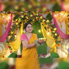 A portrait of the bride-to-be against our detailed Haldi backdrop. The combination of a grass wall, a floral arch, and draped fabrics provides a rich, textured background for photos.