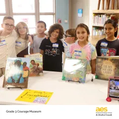 A group of proud third graders stands by their Courage Museum exhibit. Through this project, they learned that courage lives in everyday moments and that even the smallest voices can tell the biggest stories.
