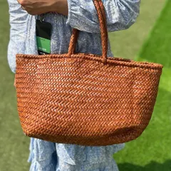 A close-up of our handwoven Juno tote in a classic timber brown. The intricate weaving pattern is a testament to the skill of our artisans.