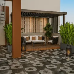 This Punjabi Bagh terrace design combines a raised wooden deck and pergola with bold, patterned flooring. The tall planters create a natural green screen, offering privacy and a lush backdrop for the cozy seating area.