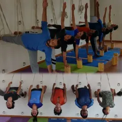 Our shala is a space for growth and community. Here, students engage in Ardha Chandrasana using blocks for alignment and explore inversions with the safety of the rope wall. This image captures the essence of our training: foundational learning supported by props and the exploration of advanced techniques.
