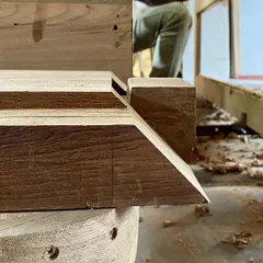 A close-up of a miter joint with a beveled edge, crafted in the workshop. Attention to these small details in wood joinery is what elevates custom furniture and ensures it lasts a lifetime.