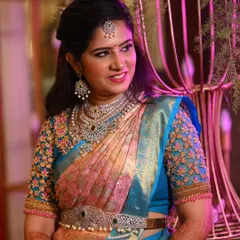 A beautiful candid shot showing her intricate blouse embroidery and how the makeup complements the pastel tones of her saree.