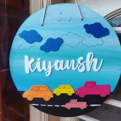 For the little car enthusiast, this nameplate features a road with colorful cars against a bright blue sky. The 3D clouds and laser-cut name add a fun, layered effect to the design.