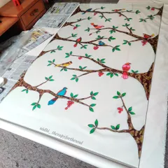 The large glass painting of birds on branches laid out in my workspace. It was a huge undertaking, and I'm so happy with how the vibrant colors turned out.