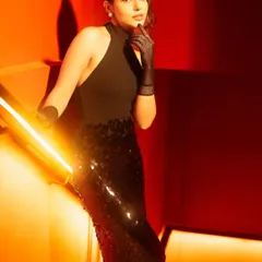 This shot is a study in using warm tungsten tones and a low key light to create drama. I teach how to use camera angles and sculpted light to elongate the frame and enhance textures like the sequins on the skirt.