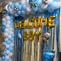 This is my classic "Welcome Boy" decoration, perfect for celebrating the arrival of a baby boy. The design includes a blue, white, and silver balloon arch complemented by a silver tinsel backdrop and cute baby-themed foil balloons.