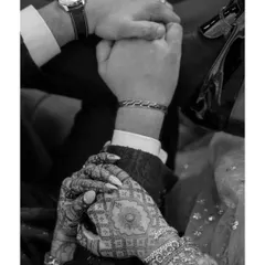 A close-up of Priyangi and Kishan holding hands. The detail of her intricate mehendi and his watch tells a story of their connection and individual styles.