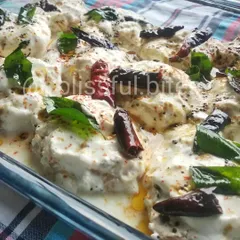 A close-up of the tempered spices, curry leaves, and dried red chilies that give my Dahi Vada its unique, delicious flavor.