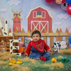 Old MacDonald had a farm, and it was adorable! This farm-themed first birthday shoot features a barn backdrop, hay, and cute animal props for a fun, rustic vibe.