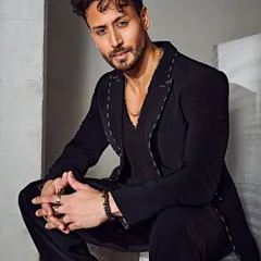 Tiger Shroff in a striking pose for a studio photoshoot. The Tisa Studio suit, paired with an Ayana Silver Jewellery neck chain, creates a look that is both sharp and contemporary.