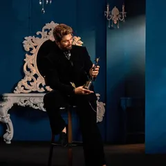 The full vision for Allu Arjun's award-winning look. Seated, you can appreciate the relaxed yet powerful drape of the Gaurav Gupta suit against the opulent backdrop, a complete vibe for the SIIMA Awards.