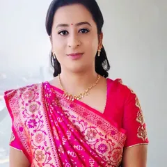 The client's complete look with a simple, wavy ponytail. This hairstyle is perfect for pairing with a beautiful saree and allows the intricate blouse details to be seen.