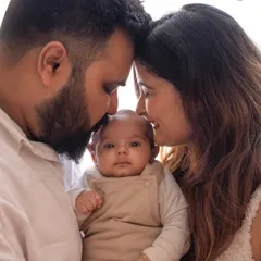 A beautiful first family portrait. The parents' gentle touch and the baby's calm gaze towards the camera make this an incredibly precious memory.