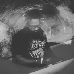 A black and white photo of me at the decks with a psychedelic projection in the background. This artistic shot captures the spiritual and meditative side of the music.